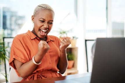 A woman looking happy at her desk at work